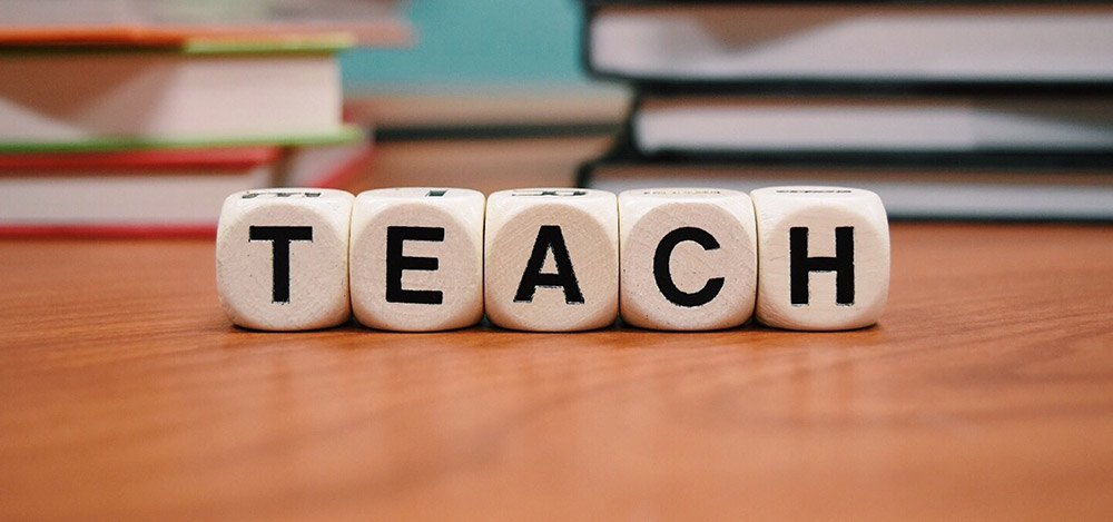 letter cubes spelling the word teach